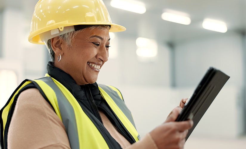 A woman uses integrated QMS and ERP software for efficient manufacturing, quality and compliance.