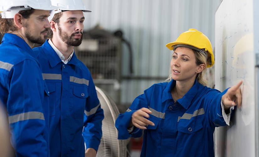 Manufacturing supervisor instructs team, supporting a culture of quality.