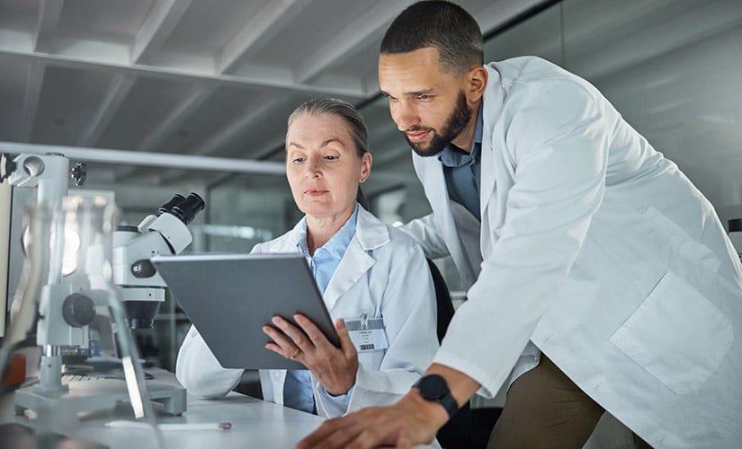 Maintaining electronic records under the FDA QMSR, two medical device technicians maintain medical device records using an eQMS.