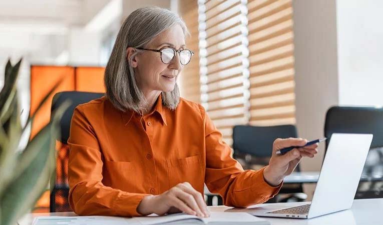Woman sitting in front of screen using document control software.