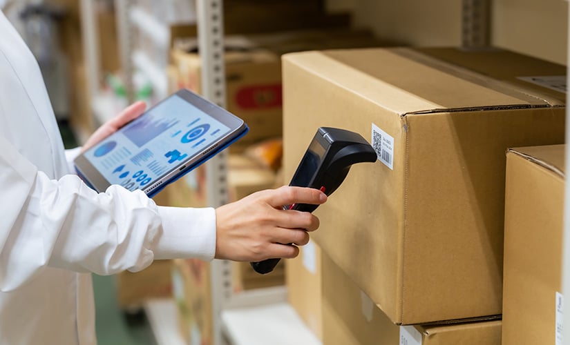 Barcode scanner and tablet with traceability software scan barcode on box to trace products.